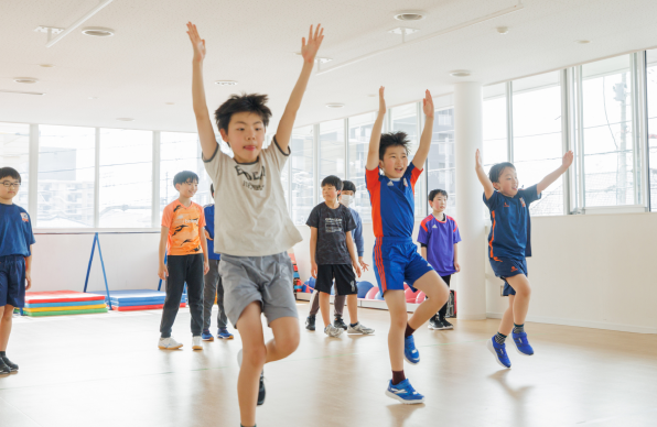 両手を挙げて運動する子供たち